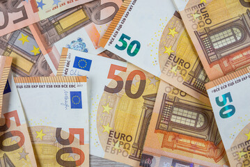 Obraz premium Pile of banknotes on the table in denominations of fifty euros.