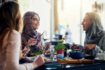 Muslim women, friends and lunch in restaurant, together and talking with food, smile and happiness. Islamic woman, group and eating brunch with conversation, happy face and listen with food in cafe