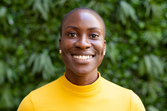 Closeup portrait of african american female professional with short hair smiling against plants
