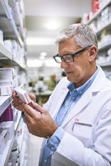 Pharmacy, medicine and reading with man at shelf in store for inspection, search and inventory. Medical, healthcare and pills with senior male pharmacist in clinic for expert, wellness and product