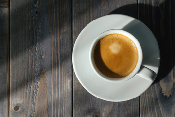 A cup of fragrant espresso on a wooden table.
