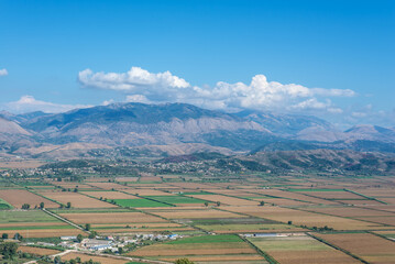 Rural landscape with agricultural fields against the background of mountains on sunny day in Saranda, South Albania. Fertile land with dramatic valley views. - 602854268
