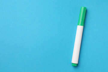 Bright green marker on light blue background, top view. Space for text