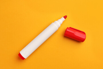 Bright red marker on orange background, flat lay