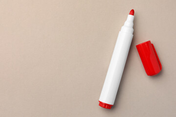 Bright red marker on beige background, flat lay. Space for text