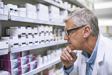 Pharmacy, medicine and thinking with man at shelf in drug store for search, inspection and...