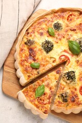 Delicious homemade vegetable quiche on light gray table, top view
