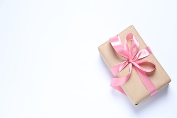 Beautiful gift box with pink bow on white background, top view. Space for text