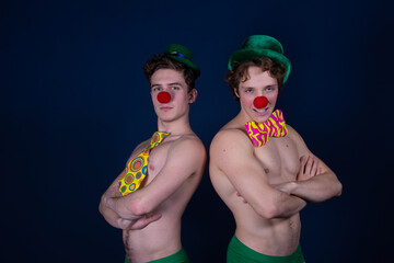 Two young attractive guys in clown costumes.