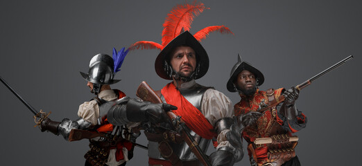 Portrait of conquistadors with steel armor and plumed helemt holding flintlock guns.