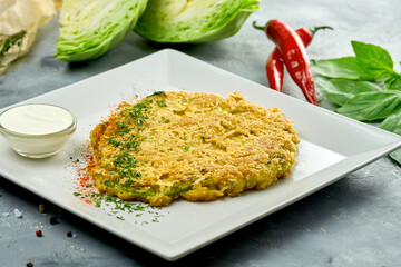 Vegetarian cabbage steak schnitzel in breadcrumbs with white sauce in a plate