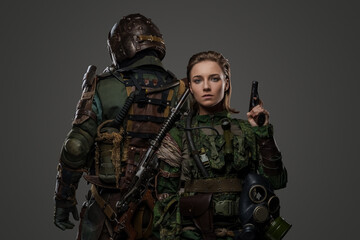 Photo of isolated on grey two female and male soldiers posing back to back. © Fxquadro
