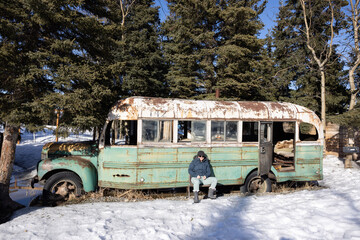 Woman sitting in front of the Into the Wild Movie Prop in Alaska