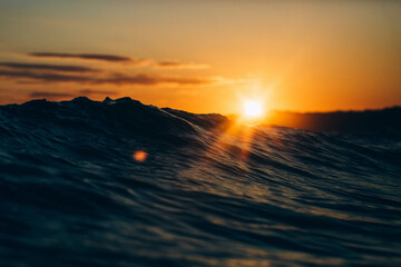 Sunrise behind the waves in St Ives bay. - obrazy, fototapety, plakaty
