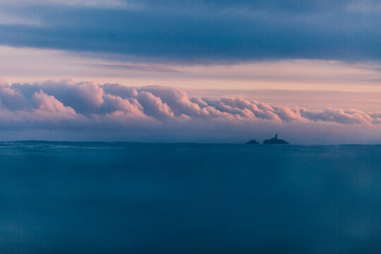 Godrevy lighthouse  at sunrise with beautiful pink clouds.