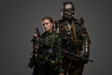 Studio shot of isolated on grey woman and man dressed in protective military suits.