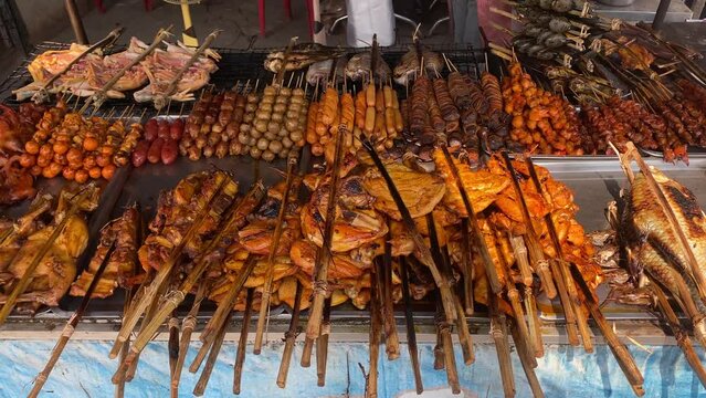 A street food vendor sells grilled marinated chicken, pork, beef and fish in Phnom Penh, Cambodia.