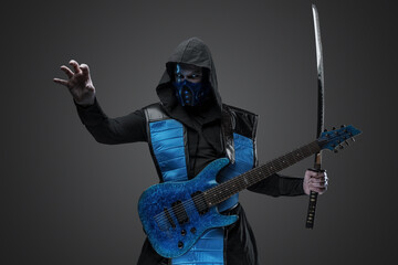 Shot of Ice assassin guitarist with katana dressed in costume with hood.