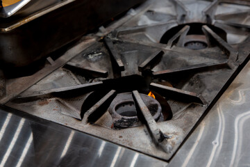 A view of a restaurant kitchen stove area, featuring the burners.