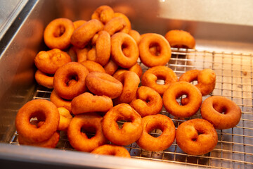 A view of a drying bin for freshly made mini donuts.