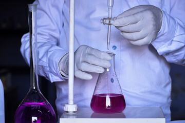 The chemist conducts acid-base titration and adding solutions