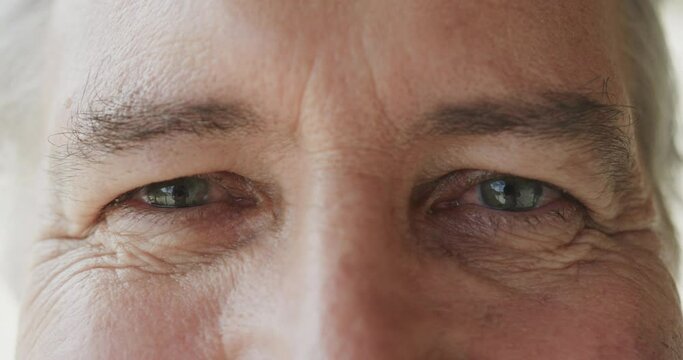 Portrait close up of the eyes of smiling senior caucasian man, in slow motion