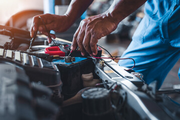 A multimeter voltmeter is used by auto mechanics to measure the voltage of a car battery.