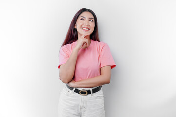 A thoughtful young woman is wearing pink t-shirt while looking aside, isolated by white background