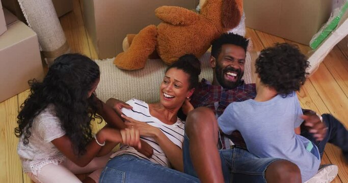 Playful, happy and surprise with family in living room for affectionate, bonding and game. Happiness, funny and tickle with parents and children playing at home for weekend, excited and love