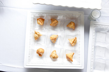 A top down view of a catered platter of mini samosas.