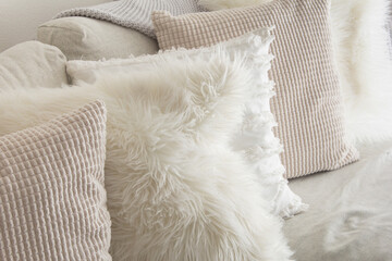 A view of a lifestyle living room scene, featuring several throw pillows on a sofa.