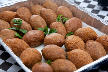 A view of a catering sized aluminum tray full of kibbeh.