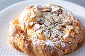 A closeup view of an almond croissant pastry.