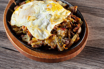 A view of a loaded potato breakfast on a skillet.