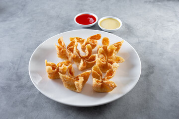 A view of a plate of cream cheese wontons.