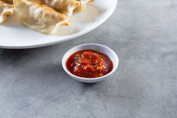 A view of a condiment cup of chili garlic sauce.