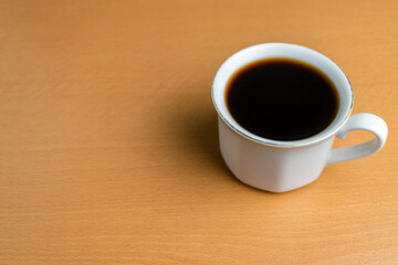 close up black coffee with white mug on wooden desk