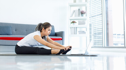 Obraz premium Portrait shot Asian beautiful healthy fit slim sexy female sporty athlete model in sportswear and leggings sitting stretching arms smiling look at camera ready for workout exercising via online video