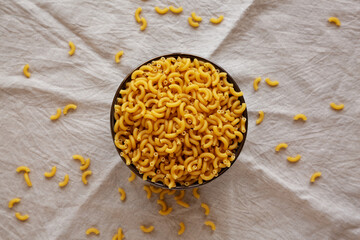 Bowl of Dry Organic Macaroni Elbow Pasta, Ready to be Cooked. Top view, overhead, from above.