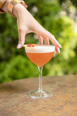 red tropical alcoholic cocktail drink in woman hand in restaurant