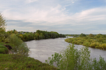Beautiful scenery, green trees, meadows, and a flooded river. 