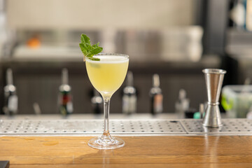 yellow cocktail with mint on the bar