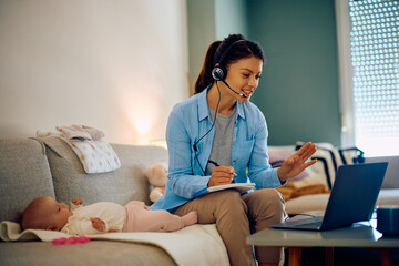 Fototapeta premium Stay at home mother talks during conference call over laptop.