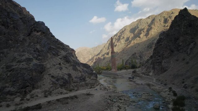 Birdseye view over deep rocky gorge of Hari River flowing next to Minaret of Jam, Afghanistan. Aerial forward