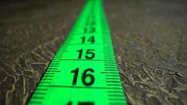 The movement of white measuring tape. Macro shot of tape-line. Centimeters in close up. Distance concept. Cross. Competition. Every step. Slim body. Weight loss.