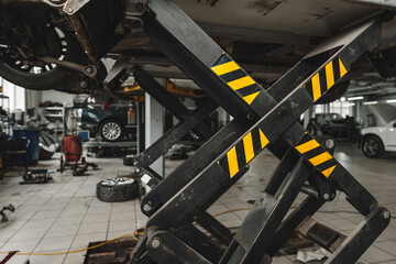 Car raised on car lift in car service shop