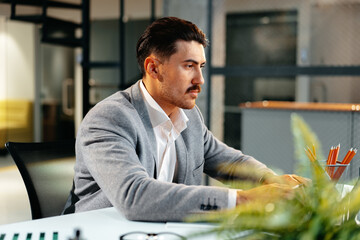 Fototapeta premium Young arab businessman working at the table in modern office