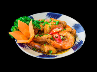 Salt fried shrimp with sauce and vegetables isolated on black backround