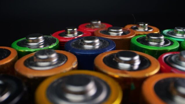 Close-up shot of old alkaline batteries, commonly known as "AA" or "AAA". Captured in macro against a dark background.