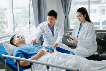 Two doctors talking to a patient lying in his bed  with receiving saline solution in hospital .